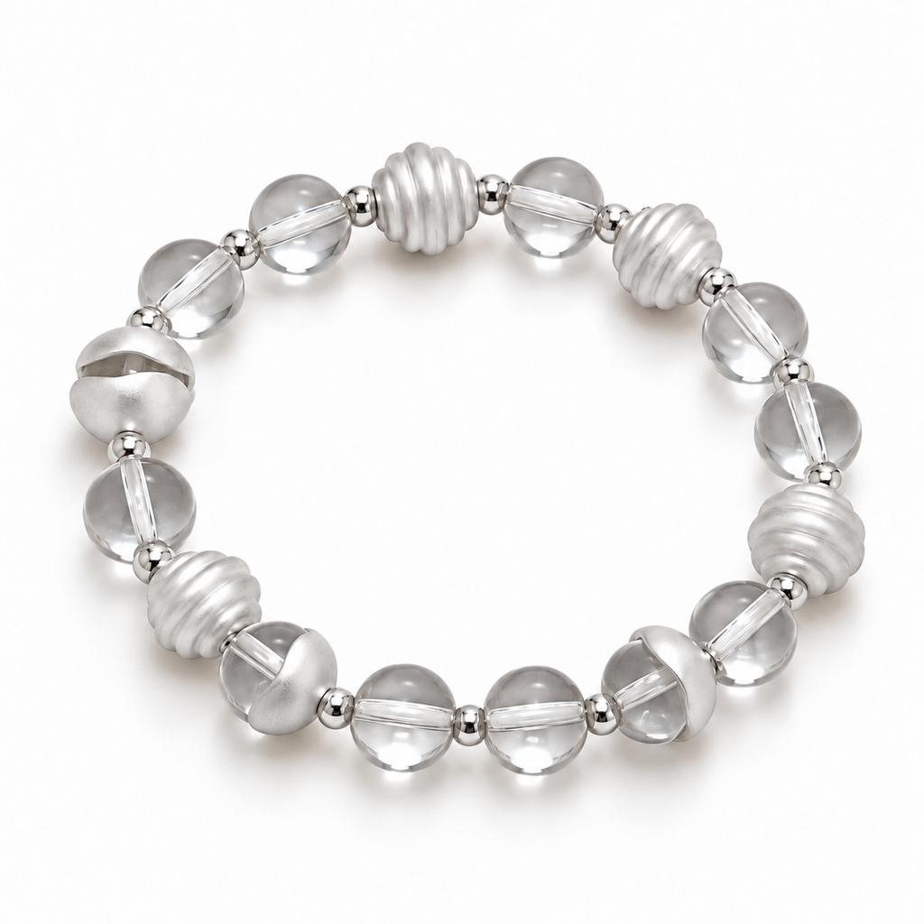 Angled view of the clear quartz bracelet showing ribbed and curved metal accents